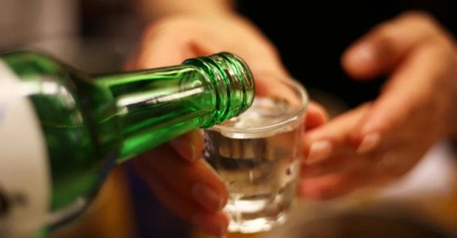 Pouring clear white soju.
